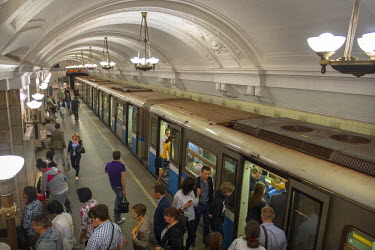 Passengers alight at Novokuznetskaya Metro Station. Opened in 1943 its murals feature battles, military figures and the workers of the Great Patriotic War (World War 2). It also uses white SIberian ma...