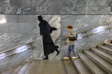 A woman passes a figure on a wall at Dostoevskaya Metro Station, opened in 2010, is named after the literary giant Fyodor Dostoevsky. The station features a mural of the great writer as well as extrac...