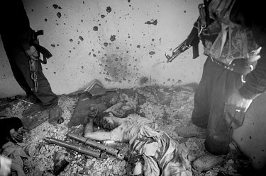 Afghan policemen guard the body of a Taliban fighter killed during clashes at the Cinema Ariana following a battle between Taliban-linked militants and security forces on 18 January 2010. At least fiv...