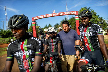 The Kenyan Riders, a Kenyan cycling team, gather before an arch over the road at the entrance of Iten which bears a slogan welcoming visitors to the 'home of champions'. The team have been training al...