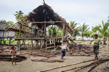 Villagers dismantle an old house.