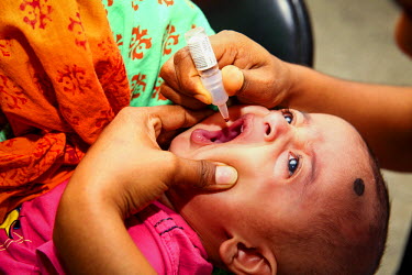 A child receives an oral vaccine at the Dhaka Shishu (Children's) Hospital at the launch of the Expanded Program on Immunisation (EPI) where the pneumococcal vaccine (PCV), which protects against one...