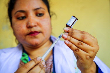Muna, a Community Health Care Provider, prepares a vaccination at a vaccination distribution centre as part of the Expanded Program on Immunisation (EPI). The pneumococcal vaccine (PCV), which protect...