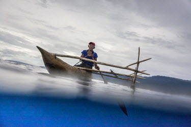 Eliuda Toxok, a shark caller from Messi village, paddles his outrigger canoe in Bismarck Sea while trying to catch a shark. Shark calling is the ancient tradition among the fishermen of New Ireland. T...