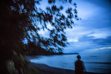 A person walks on the shore at dusk. Just 30 kilometres off Messi's beach is the site pegged for the world's first commercial deep-seabed mine Solwara 1 ('saltwater' in PNG Pidgin) operated by Canadia...