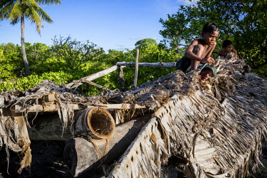 Children sit on the remains of a house destroyed by the rising seas that threaten the whole isaland nation. Abaiang is one of Kiribati's atolls that is most threatened by rising sea levels. The countr...