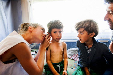 MSF doctor Anna Hoekstra examines two Afghan brothers at the charity's mobile medical centre, a camper van, in Mytiline port.