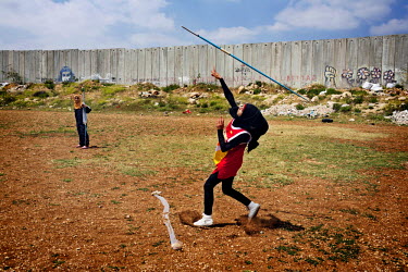 Students from the Al-Quds University javelin team engage in the last practice session before summer vacation in the West Bank city of Abu Dis, next to the Israeli Separation Wall.