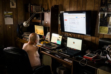 Les Baugh works on his computer setup at his home in Walden, Colorado. Baugh lost both his arms at the shoulder in a freak electrical accident 40 years ago. Since then, he has managed life mostly with...