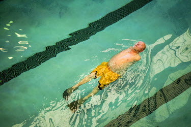 Les Baugh, 59, swims laps in a public pool in Walden, Colorado. While swimming, Les is able to mentally think through commands such as 'extend elbow' or 'rotate wrist'. He will use these when wearing...