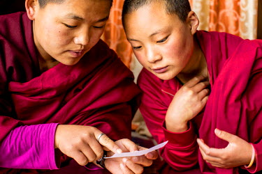 Jigme Wangmo and Thujee Zam study together at the Kela Dechen Yangtshi nunnery. Both monks and nuns keep their heads shaved and wear red robes. Much of their day is also dedicated to meditation, the p...