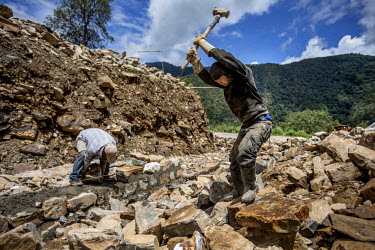 Two men work on a construction site in the Paro Valley. This new development has been built on paddy fields. Traditional farmland is being engulfed as urban centres expand to accommodate the increasin...
