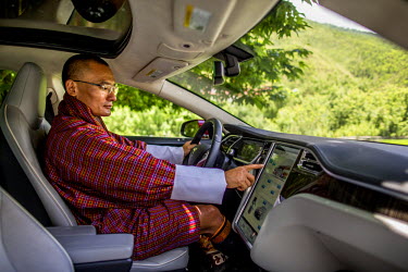 Bhutan's Prime Minister, Tshering Tobgay, sits in the driver's seat of his electric car. He is an outspoken advocate for environmental policy.