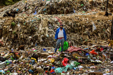 A man stands among piles of rubbish in a landfill site near Thimpu, the capital.  Thimphu's only designated landfill site reached capacity in 2002, leading to a great deal of illegal dumping.