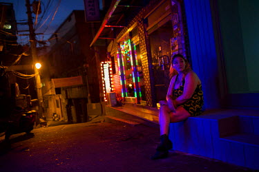 Sonia, a transgender bar worker, waits outside a bar on  Usadan-ro No. 10 in the Itaewon and Hannan neighbourhoods.