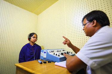 A medical worker tests the hearing of a patient at the CDD (Center for disability in Development).