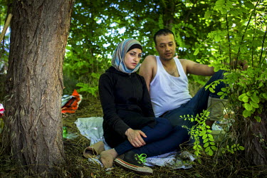 Syrian refugees, Siba, 23, and her husband, Fahad, 25, take a rest under some trees after cycling many kilometres from the Greek border. Siba was injured by sharpnel from a motar bomb in Aleppo and ha...