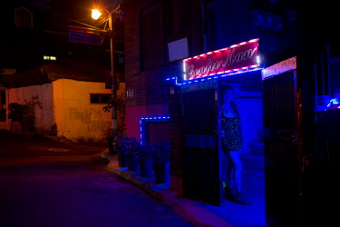 Sonia, a transgender bar worker, waits outside a bar on  Usadan-ro No. 10 in the Itaewon and Hannan neighbourhoods.