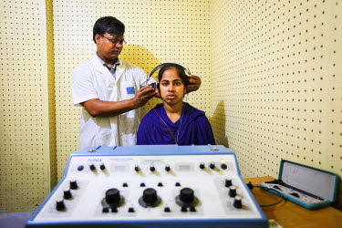 A medical worker tests the hearing of a patient at the CDD (Center for disability in Development).