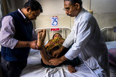 Dr. Mathew Varghese (right) and his assistant doctor inspect the leg of a patient, 21 year old Rani, on the Polio Ward of the St. Stephen's Hospital. Dr. Mathew Varghese is a polio specialist who is p...