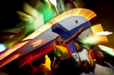 A woman dances on a table at Epo's, a popular nightspot in Accra, after watching Ghana defeat the USA on 26 June 2010 during the FIFA World Cup.