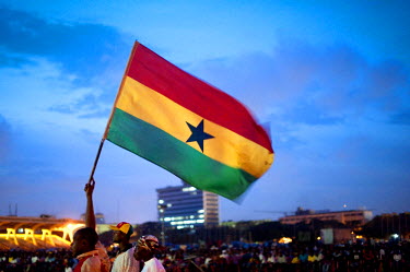 A supporter waves a Ghanaian flag at a free broadcast of the Ghana vs USA FIFA World Cup match at Independence Square in Accra on 26 June 2010.