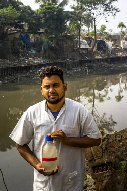 29 year old Bicky Dome, a laboratory assistant from the Institute of Serology, with a bottle of collected sewage samples to monitor the polio virus in urban Bengal.