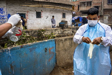 Laboratory assistants from the Institute of Serology prepare to collect the samples from a sewer in Shyam Lal lane to monitor the polio virus in urban Bengal.
