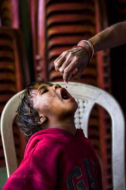 A child gets a polio vaccine on Polio Day at the Muslim Camp Basti in Dhabiatalab. On Polio Days, small booths are set up in different parts of the city, urging local residents to vaccinate all childr...