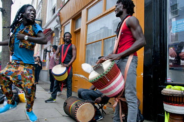 A man dances to the beat of a group of drummers playing on the pavement during the Notting Hill Carnival in West London.