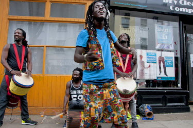 A man dances to the beat of a group of drummers playing on the pavement during the Notting Hill Carnival in West London.