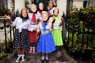 The Carnival Queens, a group of women from the Phillippines wearing masks depicting Queen Elizabeth II, dance on the doorstep of a mansion during the Notting Hill Carnival in West London.