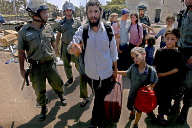 Michael Po'eh and his family are escorted from the premises of the Palm Beach Hotel, which had been taken over by about 150 right-wing Israeli squatters fighting the Israeli disengagement from Gaza. T...