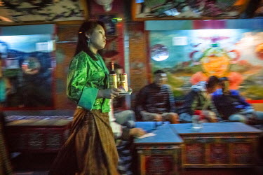 A female dancer brings a beer to a table of a customer in 'Tashi Tagay drayang' . In drayangs girls work not only as dancers, but also as waitresses. Drayangs are clubs where girls work dancing for ma...