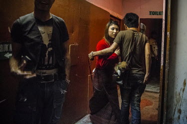 A client of 'Namsay Dzomlha', a 'drayang' (club) grabs a girl in a corridor after she danced for him. Drayangs are clubs where girls work dancing for male clients. Most of the girls come from poor rur...