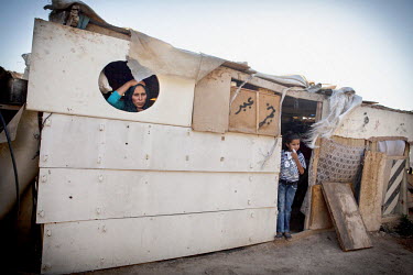 Young girls prepare for school in the living room of their makeshift shack. The older daughter volunteers in the Khan Ahmar school with dreams of pursuing an education but has no access to transportat...