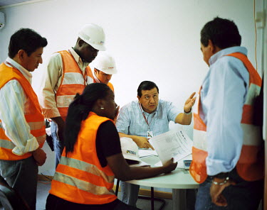 A meeting of a number of engineers working on the Cambambe Dam and Power Station in northwestern Angola. Here two Angolan ingeneers are working with four colleagues from Ecuador.