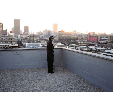 A man checks his mobile phone during a party organised on the rooftop of a building in the Central Business District which has recently been refurbished and turned into an art gallery by a promoter. D...