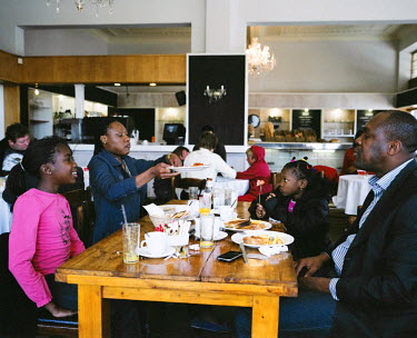 A family has lunch in a restaurant in Melville, a middle class suburb of Johannesburg which, unusually, is home to both black and white middle class families. The man on the right is a businessman fro...