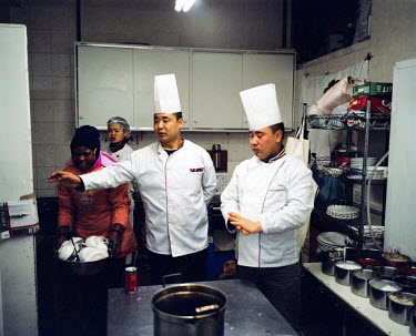 Two chefs and kitchen porters in ^Chez Li^ Chinese restaurant in Cydrildene. Johannesburg doesn't have very many Chinese restaurants yet but they are becoming more frequent and popular among the Black...