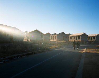 A man and woman walk along a street in Cosmo City, a huge and ongoing housing development on the northwestern outskirts of Johannesburg which is still incomplete. The development was started 20 years...