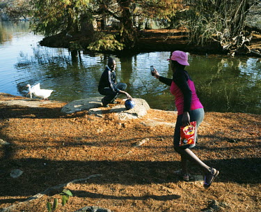 A man poses with a football next to a duck pond in Zoo Lake Park in central Johannesburg, a popular park for families to have picnics on the weekend.