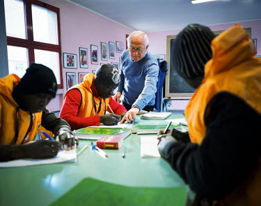 Italian lessons given by a retired Italian teacher in Esine. Every morning, these Ivorian migrants attend lessons for three hours a day then in the afternoon, they have cultural or work type activitie...