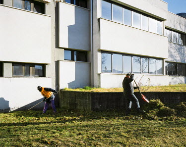 Five Senegalese migrants, all sharing the same appartment, helping a local cleaning company cutting grass and tree branches in the local school's grounds.