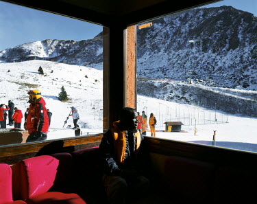 Abdou Sow, from Senegal, watches skiers through the window of a hotel. In 2011 a group of African migrants arrived by boat on the Italian island of Lampedusa. In July the same year the Italian governm...