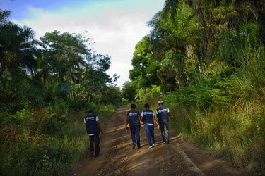 Members of a World Health Organisation (WHO) team working in the village of Tana walk down a country track.  In this region the WHO has decided to allow people who have been in contact with Ebola pati...