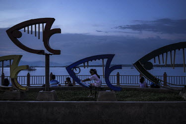 A child plays on the fished shapped sculptures by the bay in Puerto Princesa.