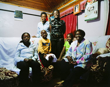 Joy's family at her home. At the top left is her cleaning lady who works full time and helps out with shopping, cleaning, laundry etc.