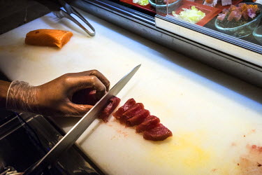 A chef slices a sustainably caught yellowfin tuna for sushi at a restaurant in the Marco Polo Hotel in Ortigas.