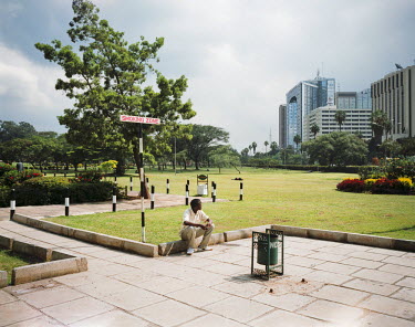 A man rests in a park in the centre of Nairobi. It is the showcase of the city, but also a place where homeless people spend the night, and can still be seen on the grass in the morning.